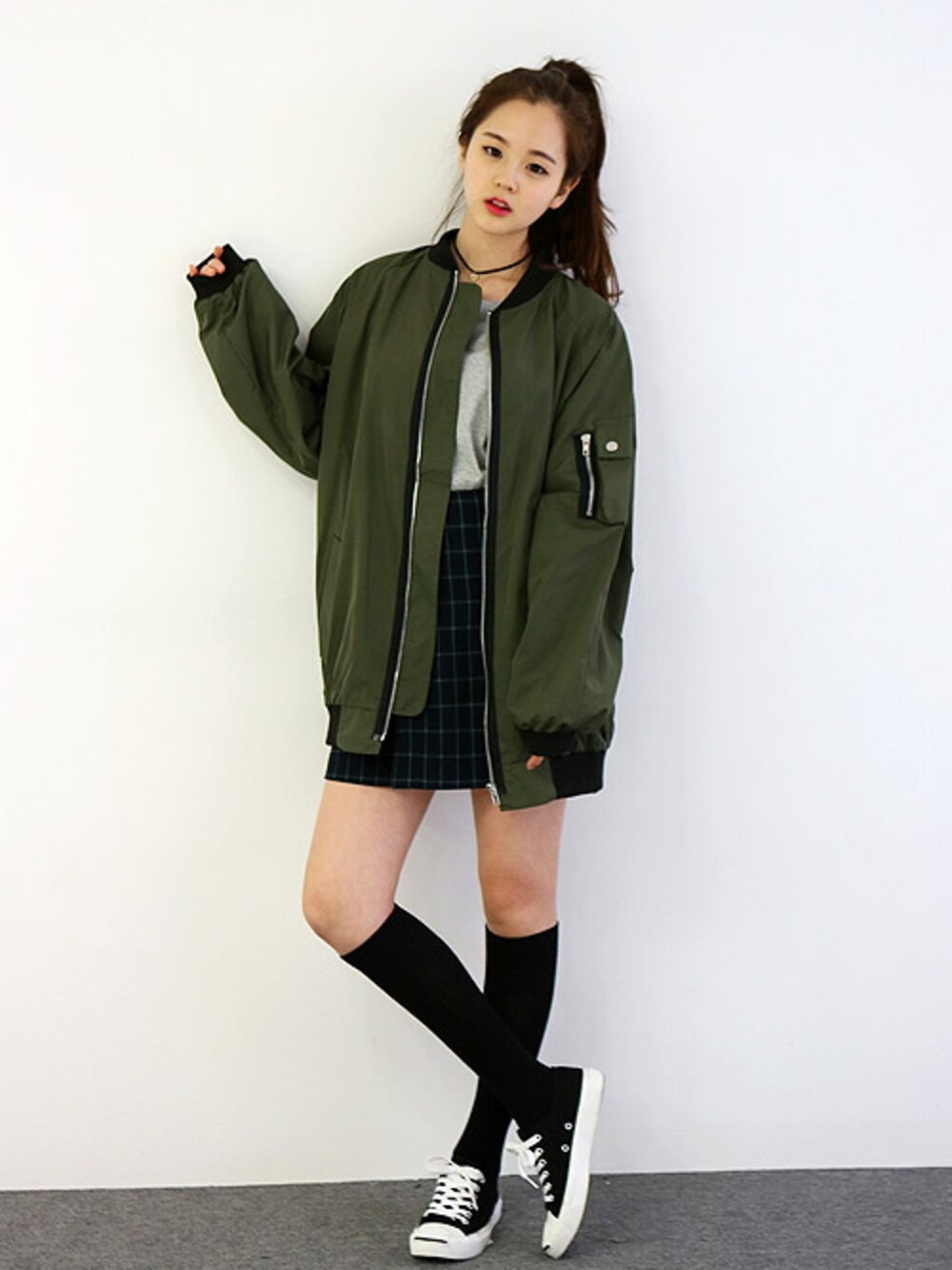 グリーン系のスタジャンを着用したレディースの冬コーディネートの1枚目の写真