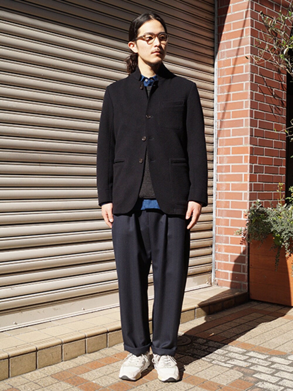 ブラック系のノーカラージャケット、ブラウン系のニット/セーター、ブルー系のその他パンツを着用したメンズの冬コーディネートの1枚目の写真