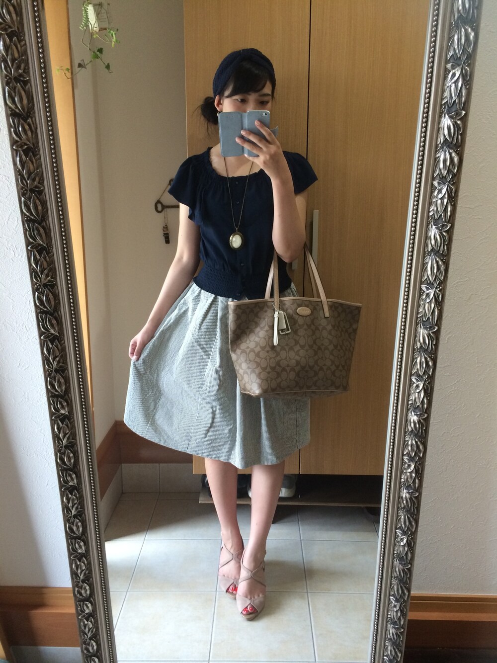 ベージュ系のサンダル、ベージュ系のトートバッグ、ブルー系のトップスを着用したレディースの夏コーディネートの1枚目の写真