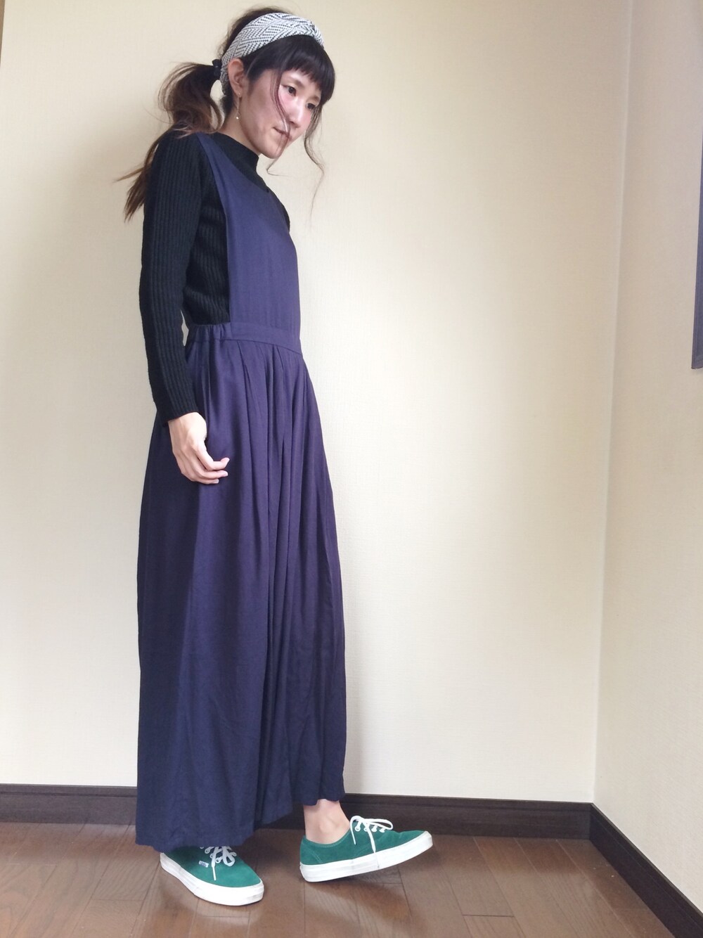 ブルー系のサロペット/オーバーオール、ブラック系のニット/セーター、グリーン系のスニーカーを着用したレディースの秋コーディネートの1枚目の写真