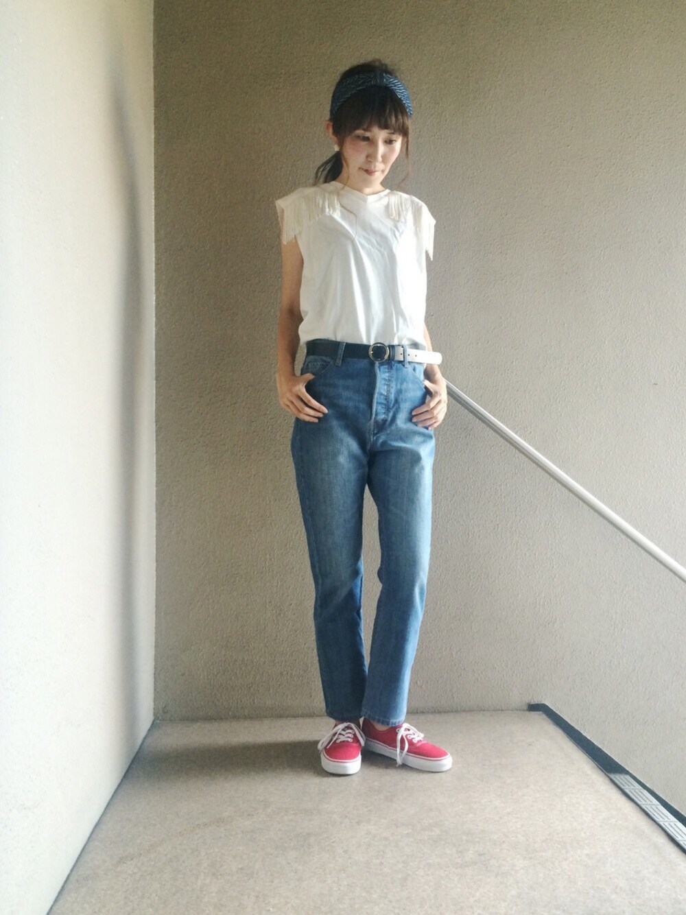 ホワイト系のTシャツ/カットソー、ブルー系のデニムパンツ、レッド系のスニーカーを着用したレディースの秋コーディネートの1枚目の写真