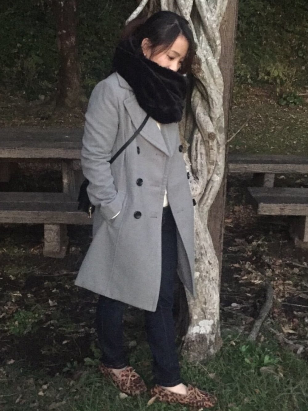 グレー系のチェスターコート、ブルー系のデニムパンツ、その他のモカシン/デッキシューズを着用したレディースの冬コーディネートの1枚目の写真