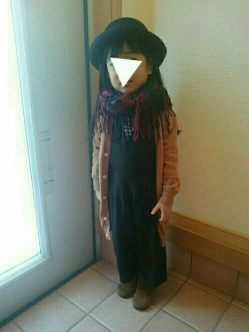ブラック系のサロペット/オーバーオール、ブラウン系のブーツ、ブラウン系のカーディガン/ボレロを着用したキッズの秋コーディネートの1枚目の写真