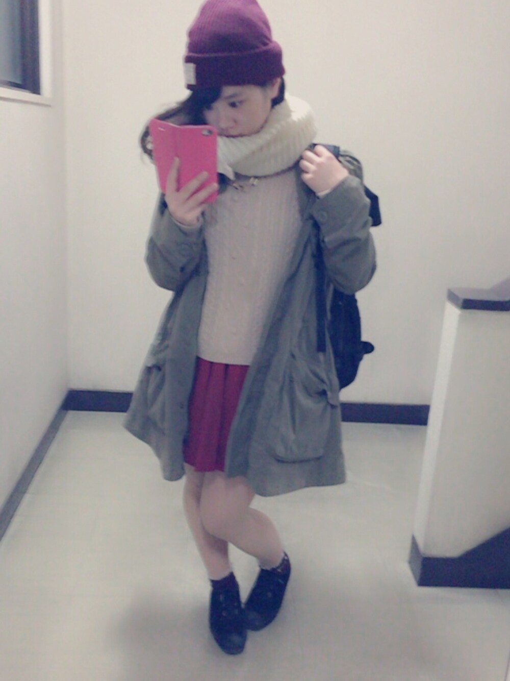 グリーン系のダウンジャケット/コート、ブラック系のブーティ、レッド系のスカートを着用したレディースの冬コーディネートの1枚目の写真