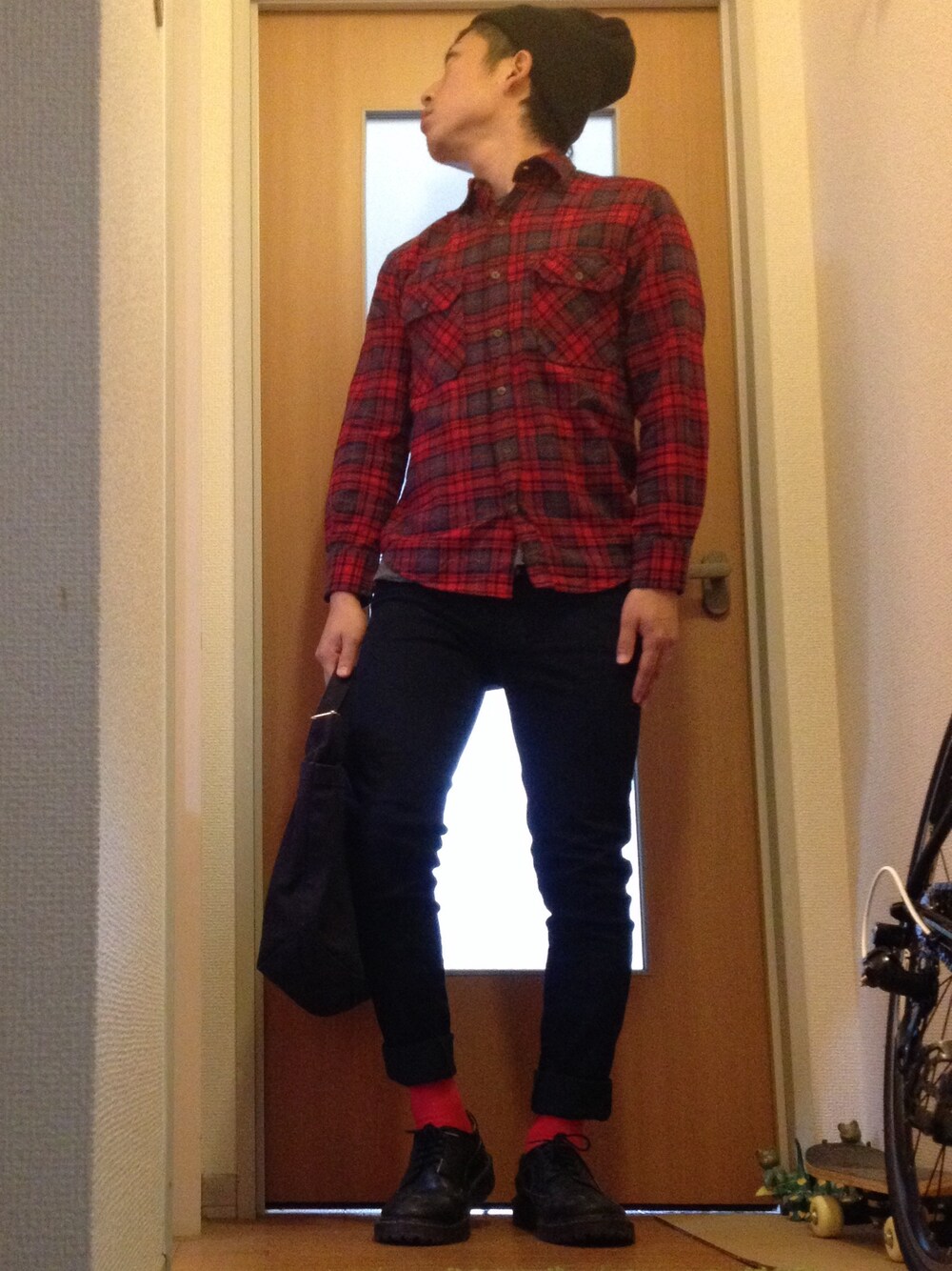 レッド系のシャツ/ブラウス、ブラック系のトートバッグ、ブラック系のブーツを着用したメンズの秋コーディネートの1枚目の写真