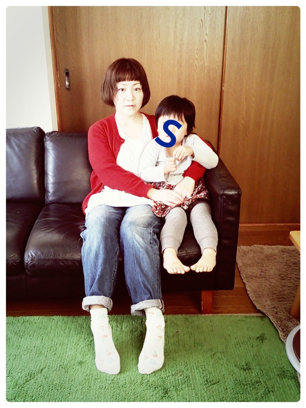 レッド系のカーディガン/ボレロ、ブルー系のデニムパンツを着用したレディースの秋コーディネートの1枚目の写真