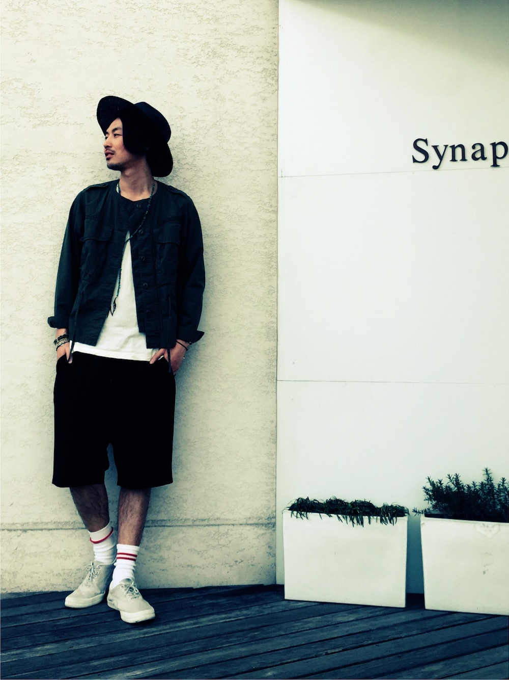 グリーン系のミリタリージャケット、ブラック系のスラックスを着用したメンズの春コーディネートの1枚目の写真