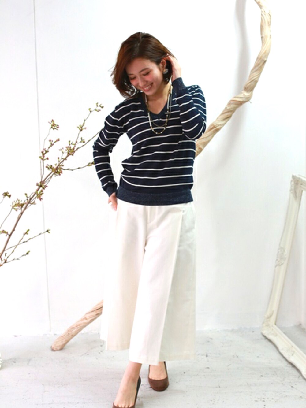 ブルー系のニット/セーターを着用したレディースの春コーディネートの1枚目の写真