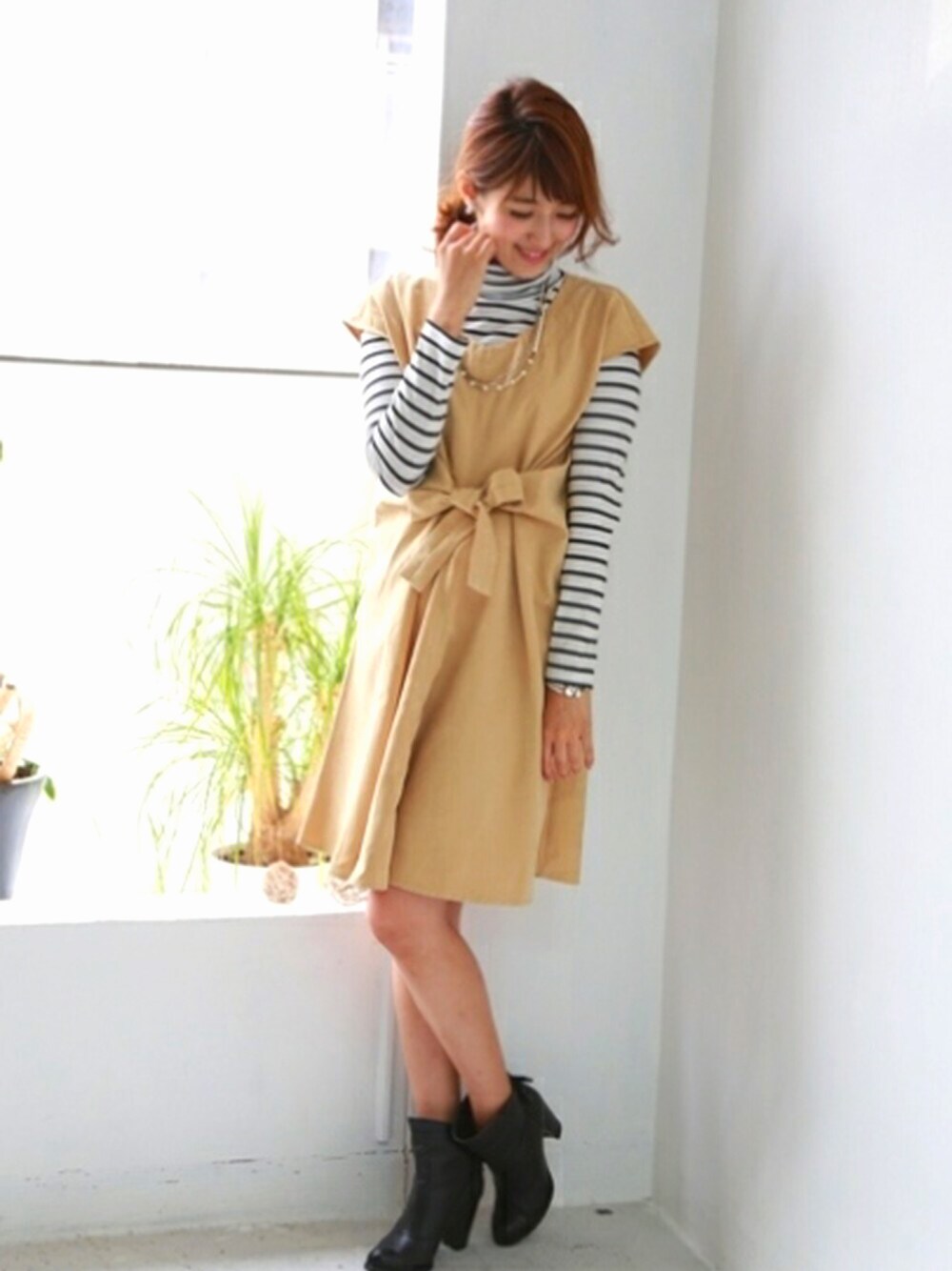 グリーン系のワンピース、ホワイト系のニット/セーターを着用したレディースの春コーディネートの1枚目の写真