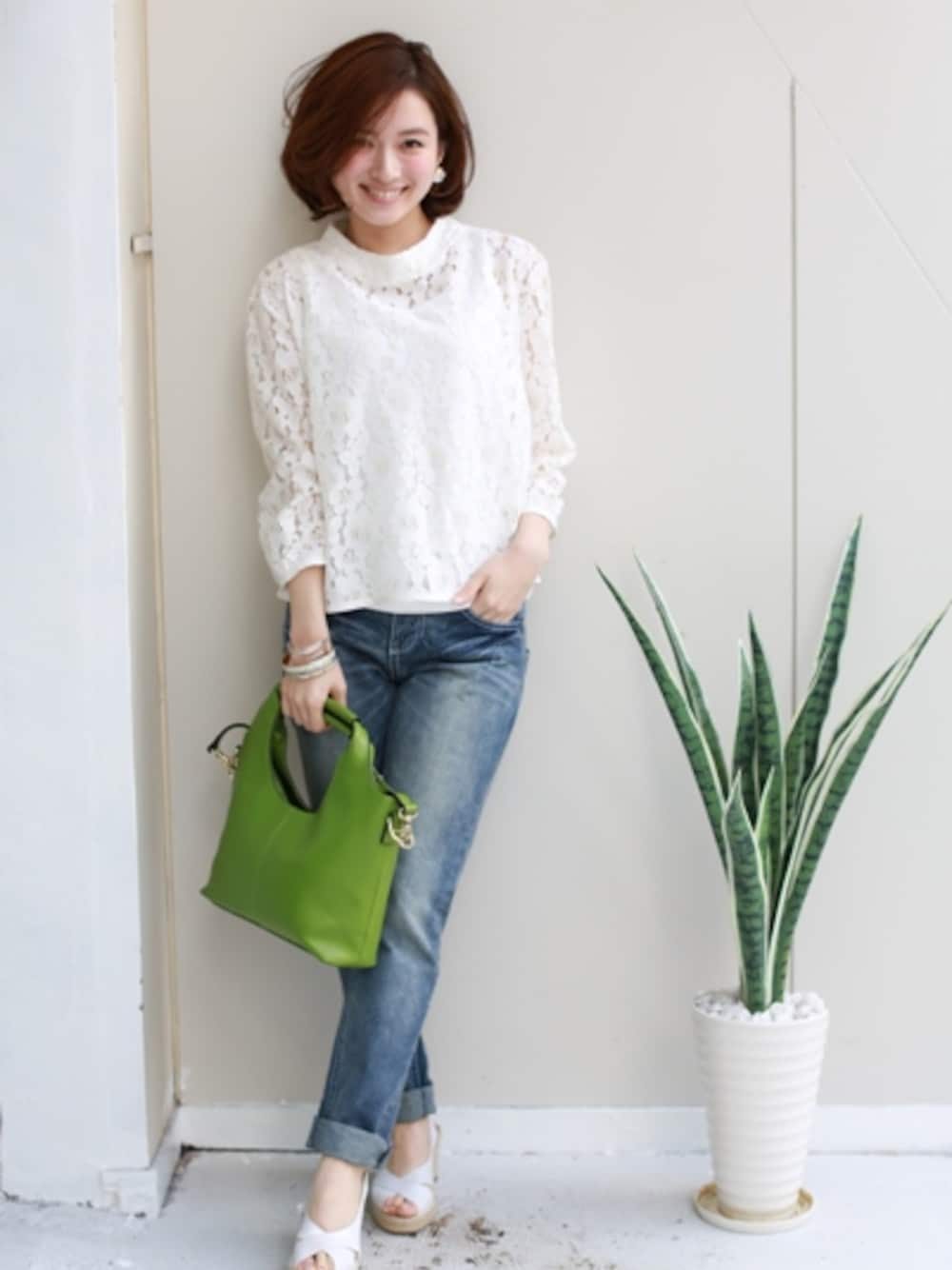 ホワイト系のタンクトップ、イエロー系のショルダーバッグ、ブルー系のデニムパンツを着用したレディースの春コーディネートの1枚目の写真