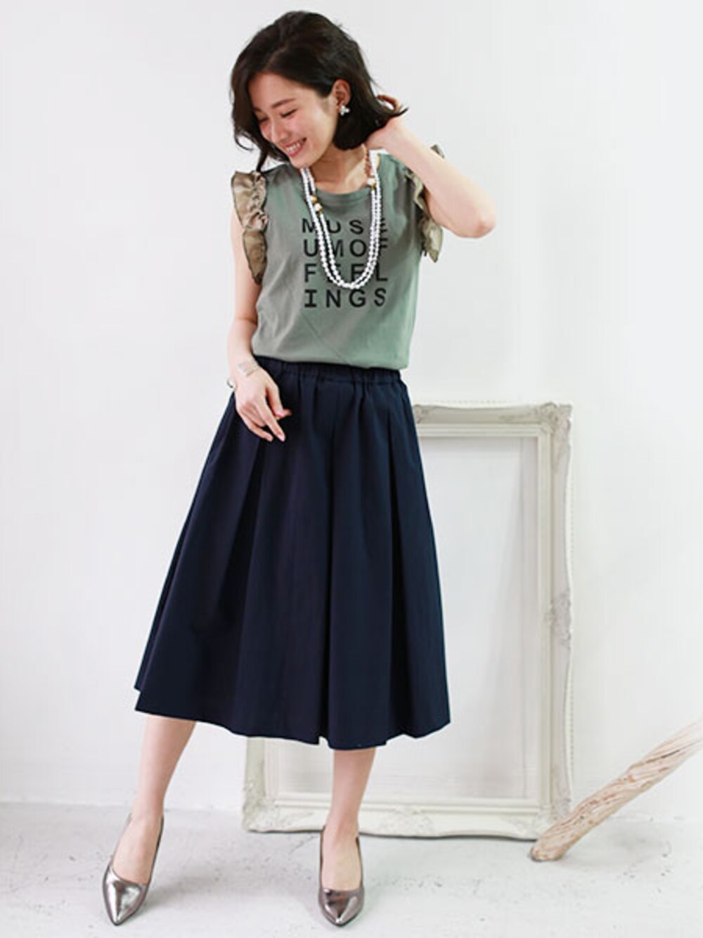 グリーン系のタンクトップを着用したレディースの春コーディネートの1枚目の写真