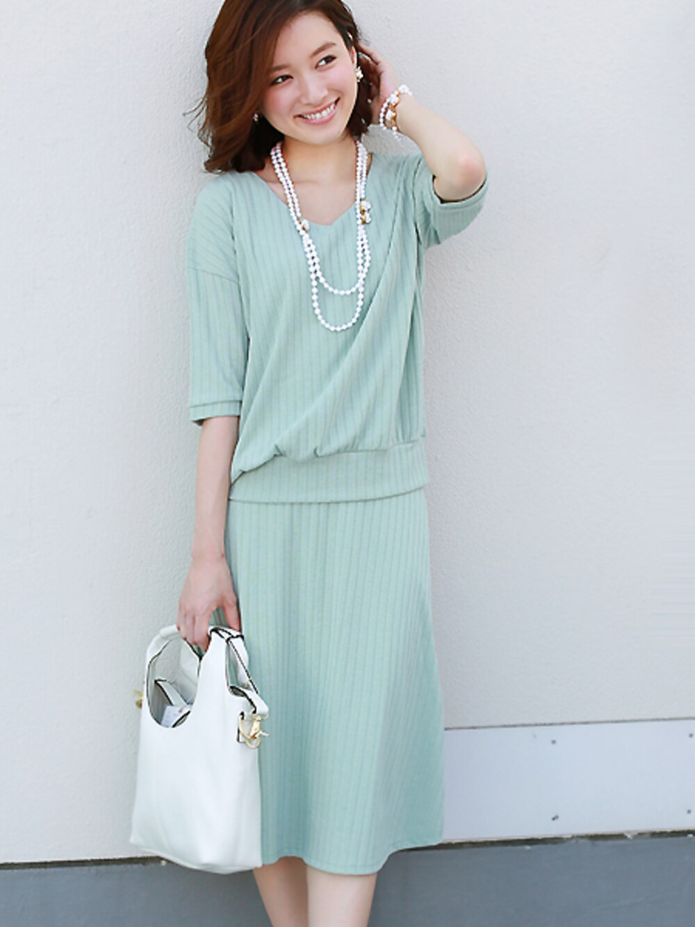 グリーン系のワンピースを着用したレディースの春コーディネートの1枚目の写真