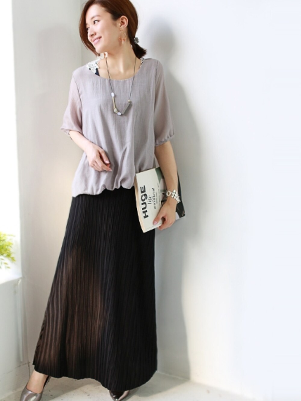 グリーン系のスカートを着用したレディースの夏コーディネートの1枚目の写真