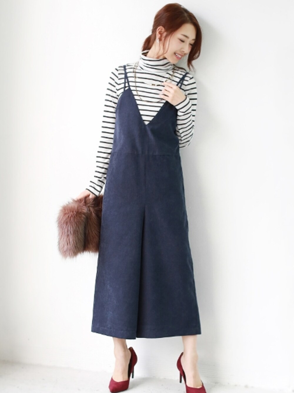 ブルー系のつなぎ/オールインワン、ホワイト系のニット/セーター、ゴールド系のネックレスを着用したレディースの秋コーディネートの1枚目の写真