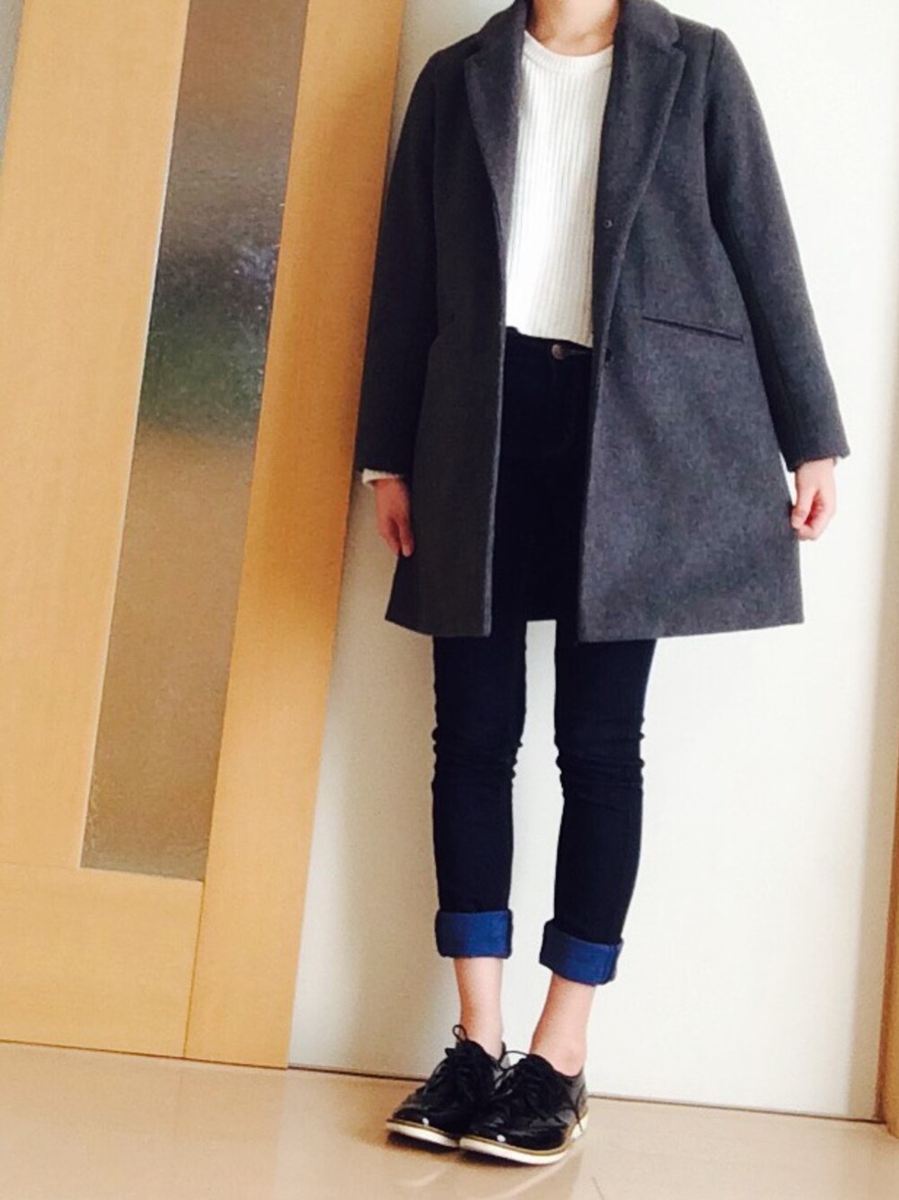 ホワイト系のニット/セーター、グレー系のチェスターコート、ブラック系のその他シューズを着用したレディースの冬コーディネートの1枚目の写真