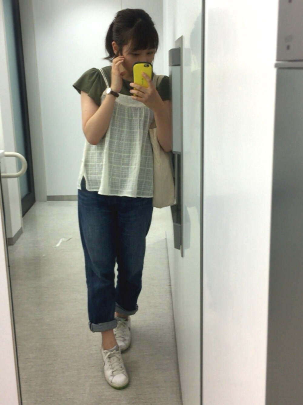 ブルー系のデニムパンツ、ホワイト系のスニーカー、ベージュ系のキャミソールを着用したレディースの夏コーディネートの1枚目の写真