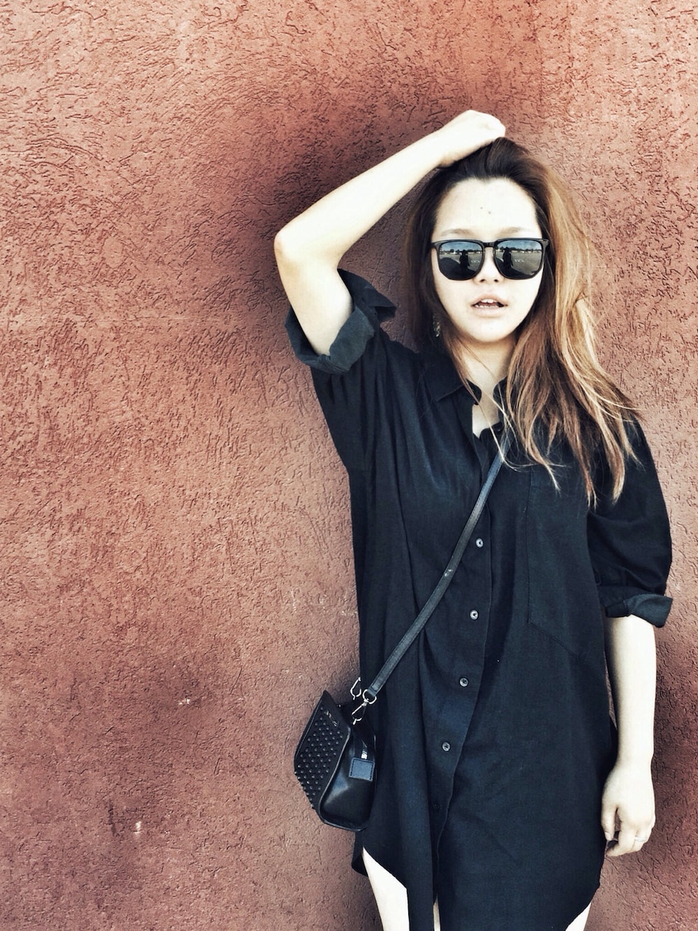 ブラック系のシャツワンピース、ブラック系のハンドバッグを着用したレディースの夏コーディネートの1枚目の写真