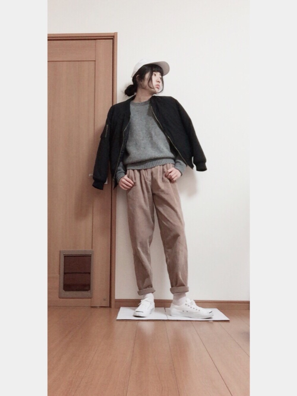 ブラック系のジャケット/アウター、ベージュ系のパンツ、ホワイト系のスニーカーを着用したレディースの冬コーディネートの1枚目の写真