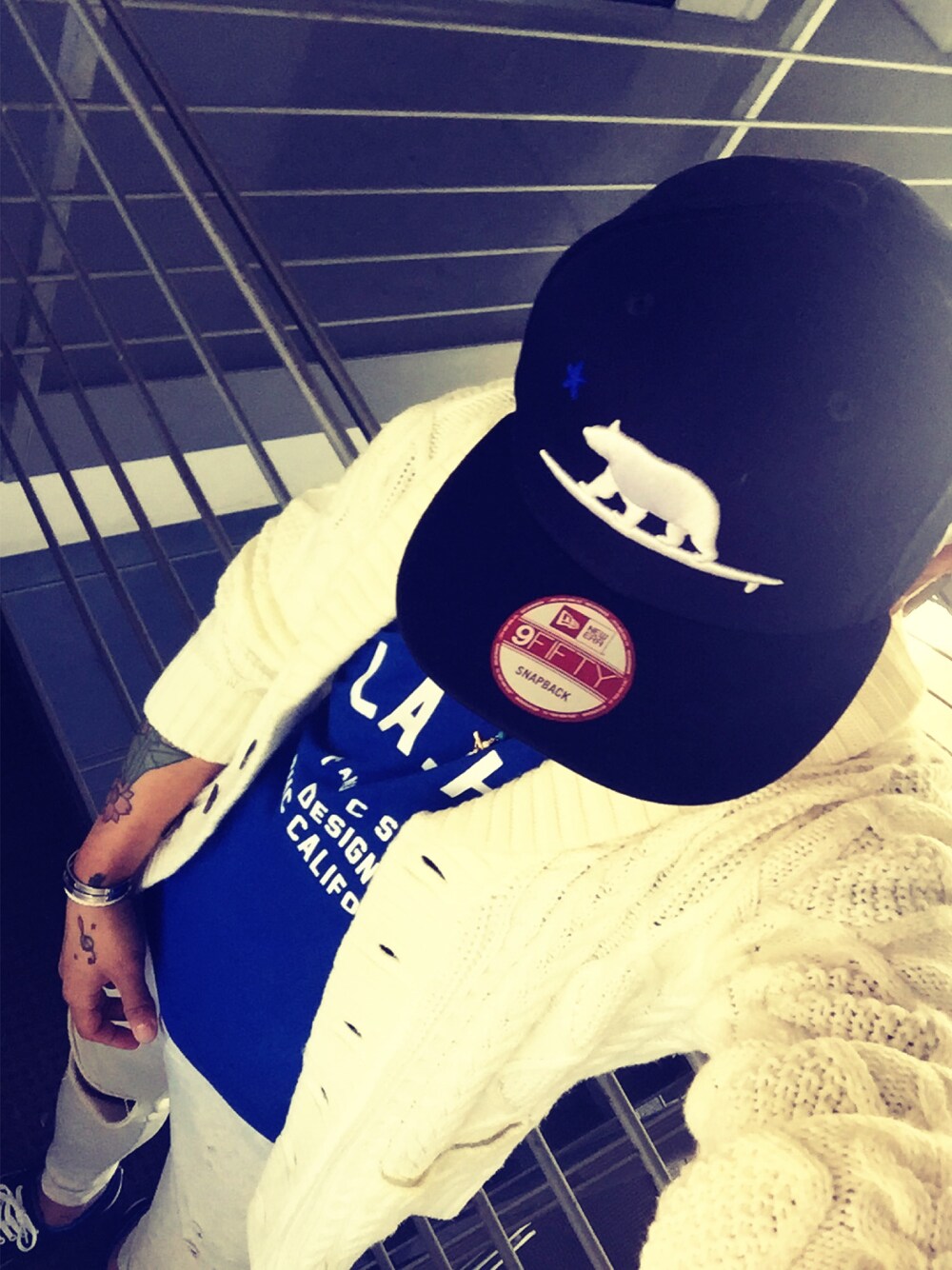 ブルー系のTシャツ/カットソー、グレー系のその他パンツ、ブルー系のキャップを着用したメンズの冬コーディネートの1枚目の写真