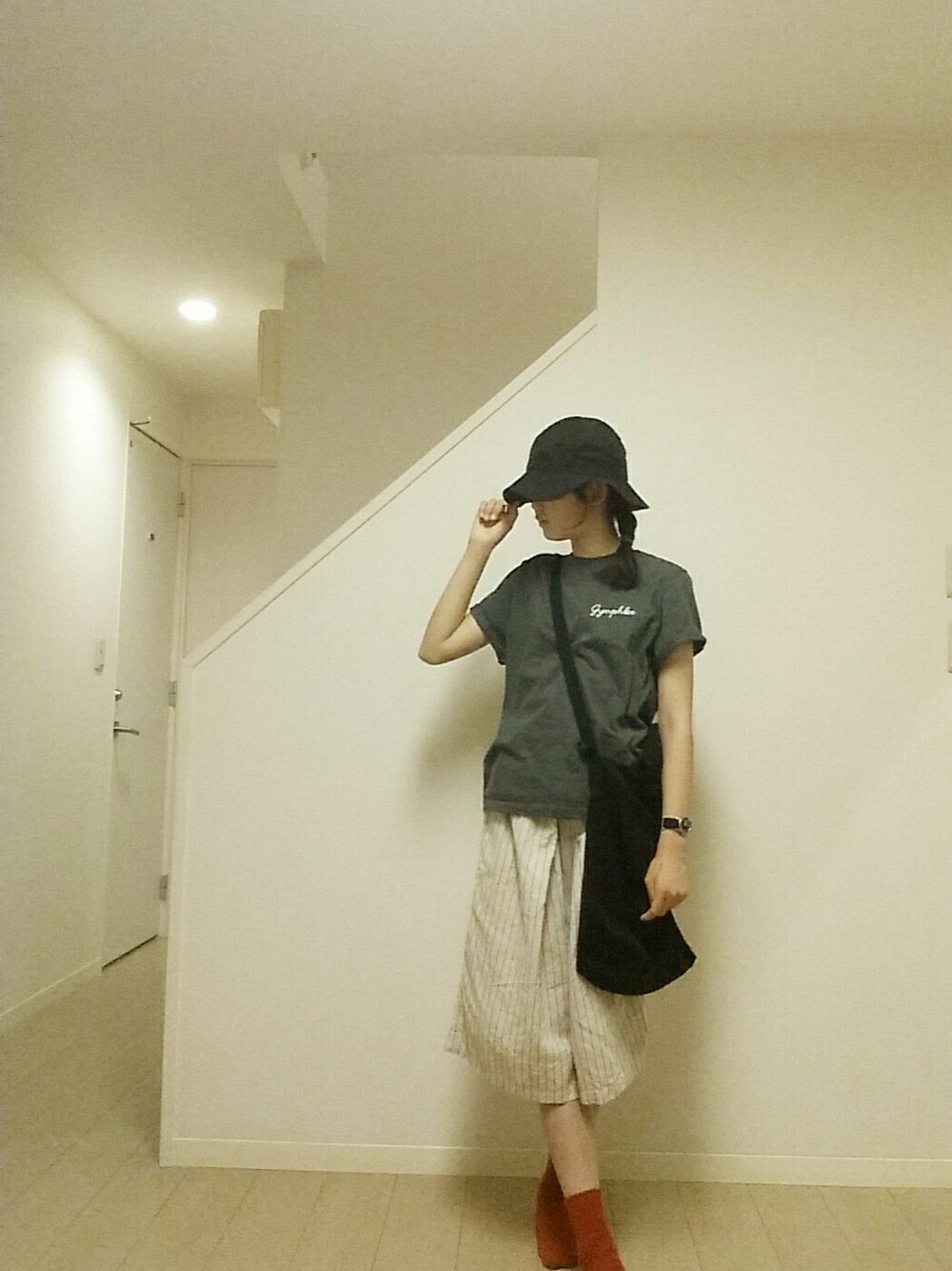 グレー系のTシャツ/カットソー、ブラック系のアナログ腕時計、ブラック系のハットを着用したレディースの夏コーディネートの1枚目の写真