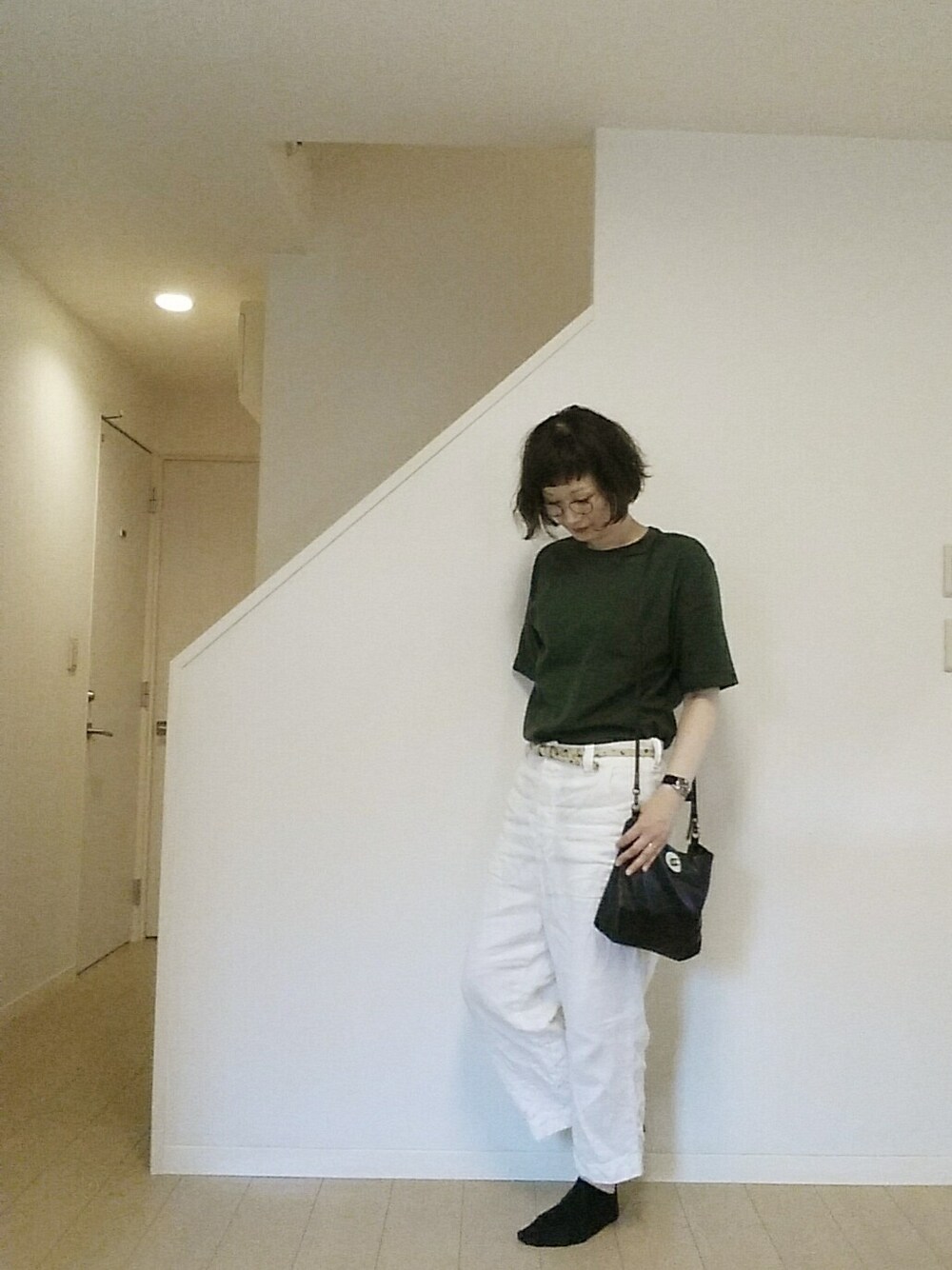 ブラック系のショルダーバッグ、グレー系のスニーカー、ブルー系のTシャツ/カットソーを着用したレディースの夏コーディネートの1枚目の写真