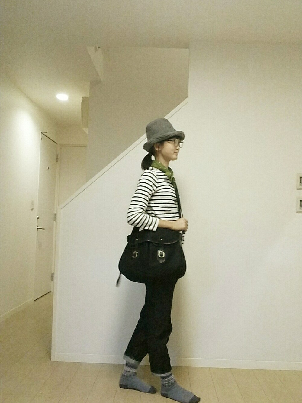 ブラック系のショルダーバッグ、ホワイト系のTシャツ/カットソー、ブルー系のデニムパンツを着用したレディースの秋コーディネートの1枚目の写真