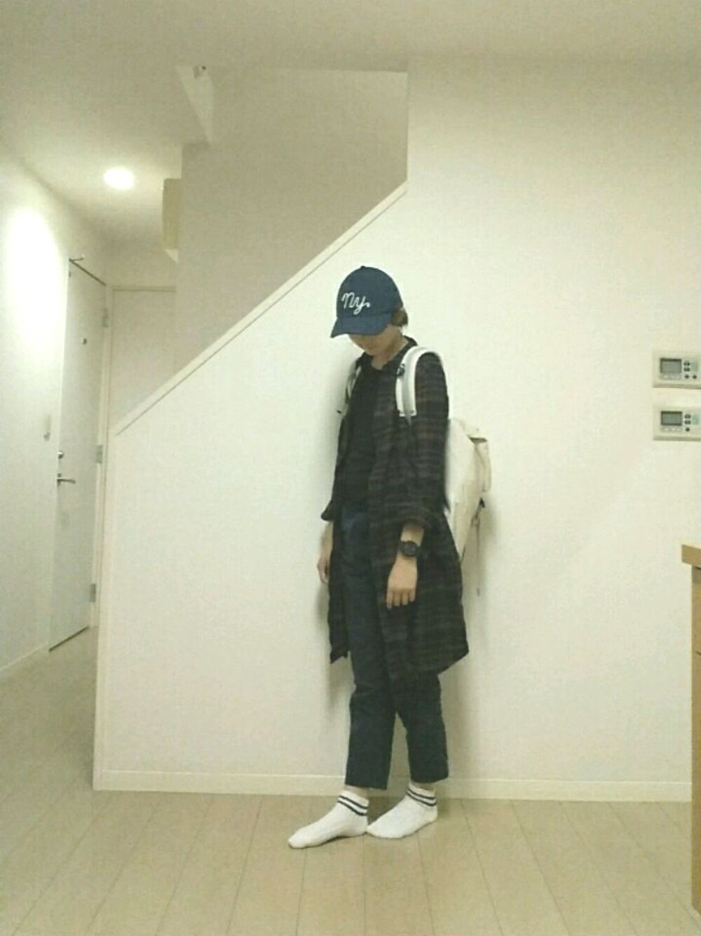 レッド系のシャツワンピース、ブラック系のアナログ腕時計、ブルー系のキャップを着用したレディースの秋コーディネートの1枚目の写真