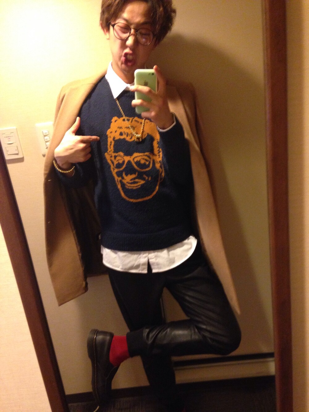 ブルー系のニット/セーター、ベージュ系のチェスターコート、ブラック系のその他パンツを着用したメンズの冬コーディネートの1枚目の写真