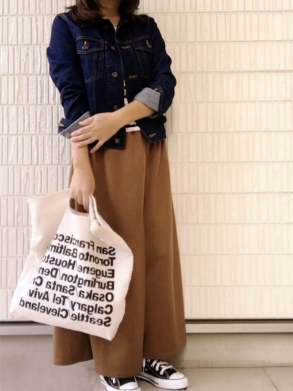 ベージュ系のその他パンツ、ブルー系のデニムジャケット、ホワイト系のトートバッグを着用したレディースの秋コーディネートの1枚目の写真
