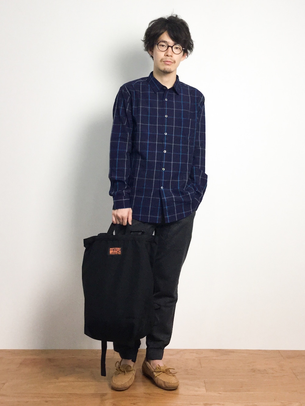 「バックパック、チェックシャツ、ミネトンカ、モカシン、黒リュック、ミステリーランチ、ジョガーパンツ、青チェック、青チェックシャツ」｜「MYSTERY RANCHのMYSTERY RANCH/ミステリーランチ　BOOTY  BAG　(554)（バックパック/リュック、ブラック系）」を使った、ナカニシアキラさん（メンズ・172cm）の秋コーディネートの1枚目の写真