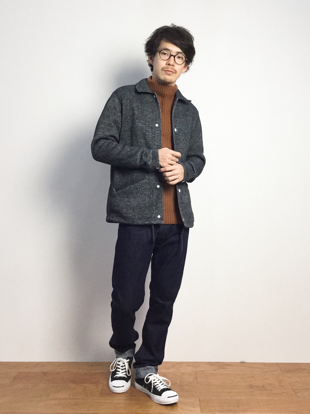 グレー系のブルゾン、イエロー系のニット/セーター、ブルー系のデニムパンツを着用したメンズの秋コーディネートの1枚目の写真