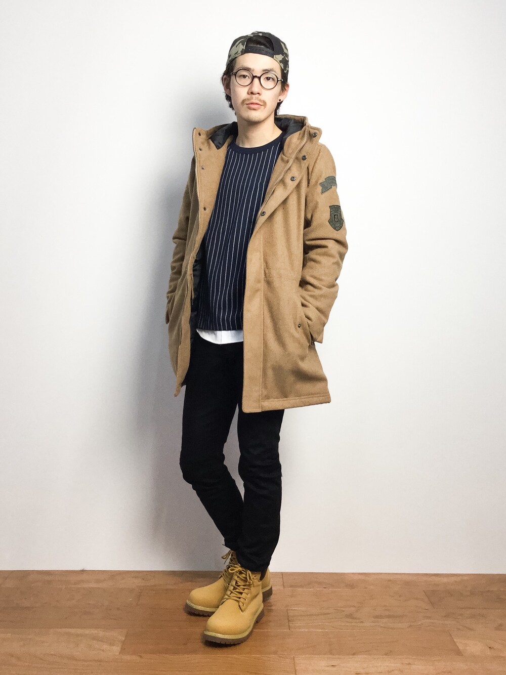 「モッズコート、黒スキニー、キャップ後ろかぶり、キャップ×メガネ」｜「chapter worldのabsolute777 / ストーム付きアウトドアブーツ_abi（ブーツ、イエロー系）」を使った、ナカニシアキラさん（メンズ・172cm）の秋コーディネートの1枚目の写真