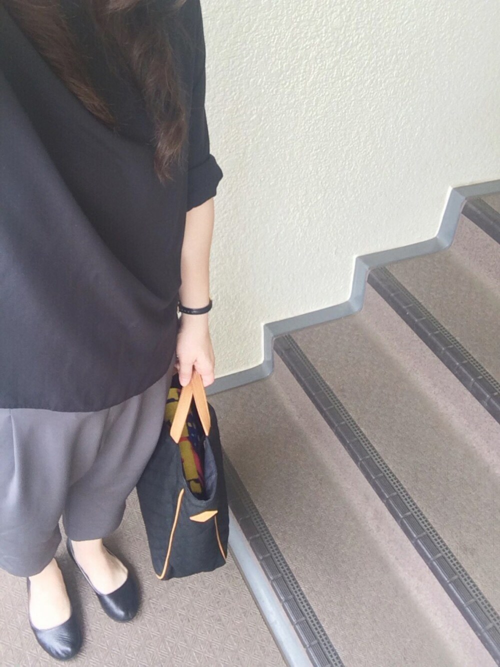 ブラック系のトップス、グレー系のパンツ、ブラック系のトートバッグを着用したレディースの夏コーディネートの1枚目の写真