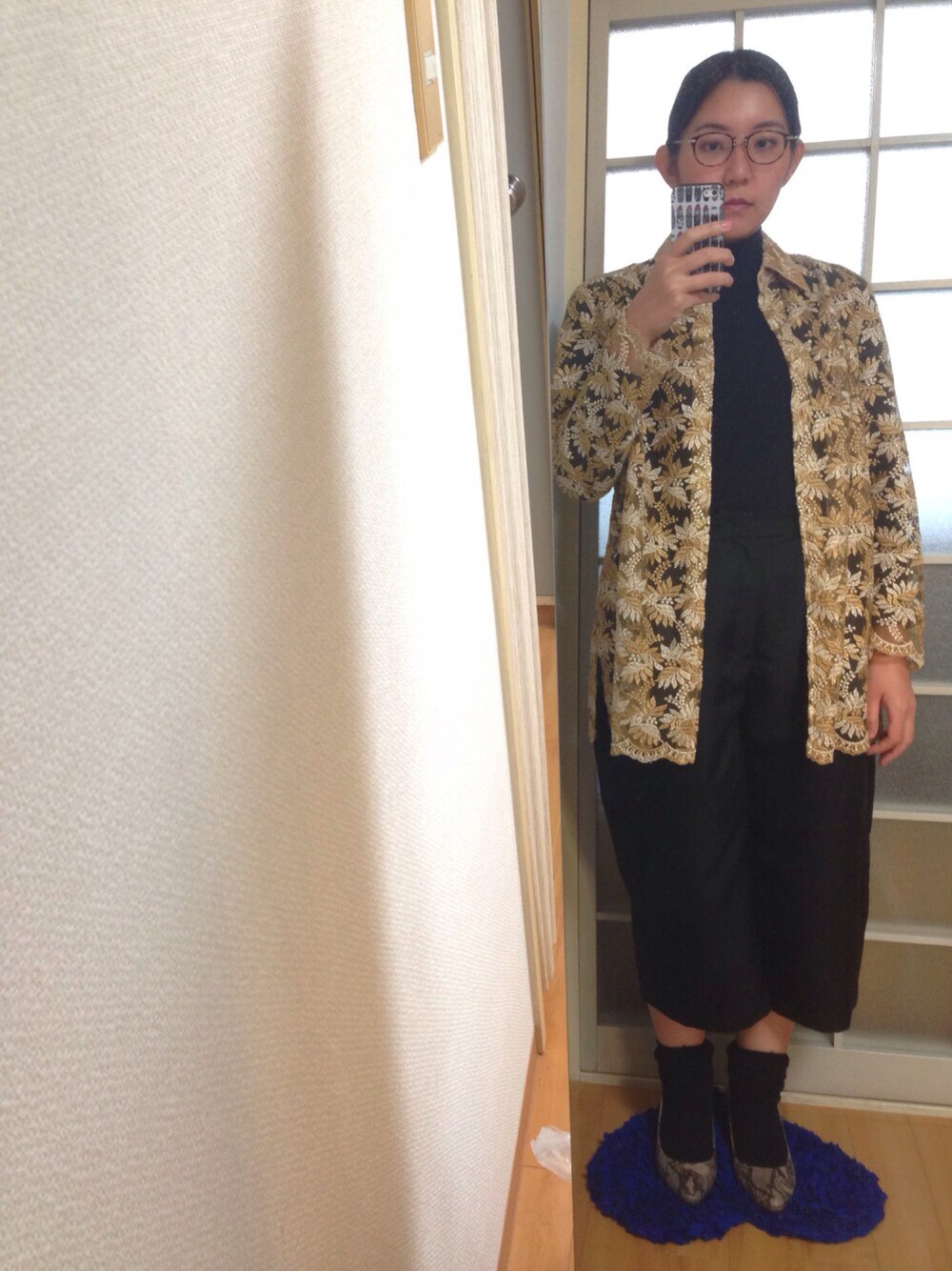 ゴールド系のシャツ/ブラウス、ブラック系のTシャツ/カットソー、ブラック系のパンツを着用したレディースの秋コーディネートの1枚目の写真