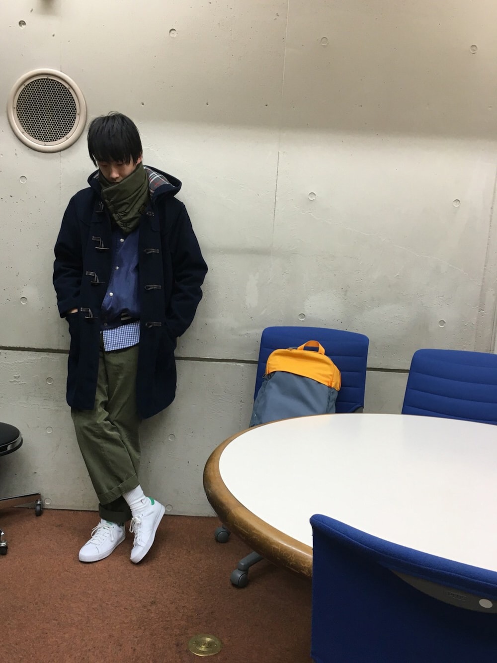 ブルー系のダッフルコート、ブルー系のブルゾン、オレンジ系のバックパック/リュックを着用したメンズの冬コーディネートの1枚目の写真