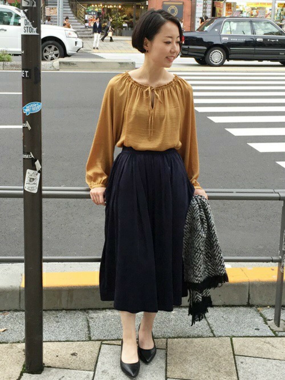 イエロー系のシャツ/ブラウス、ブルー系のその他パンツ、ブラック系のパンプスを着用したレディースの秋コーディネートの1枚目の写真