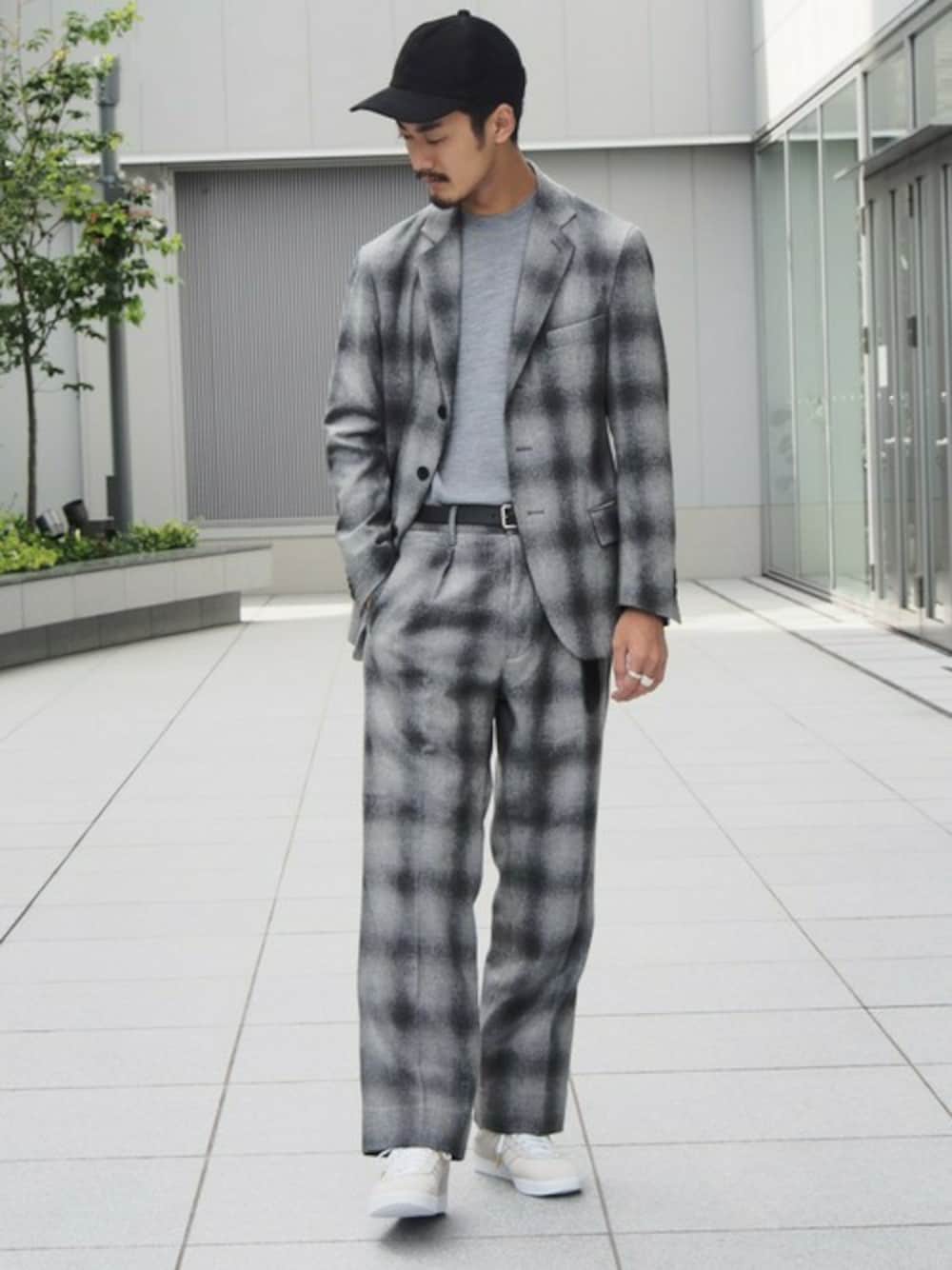 グレー系のテーラードジャケット、グレー系のスラックス、ホワイト系のスニーカーを着用したメンズの秋コーディネートの1枚目の写真