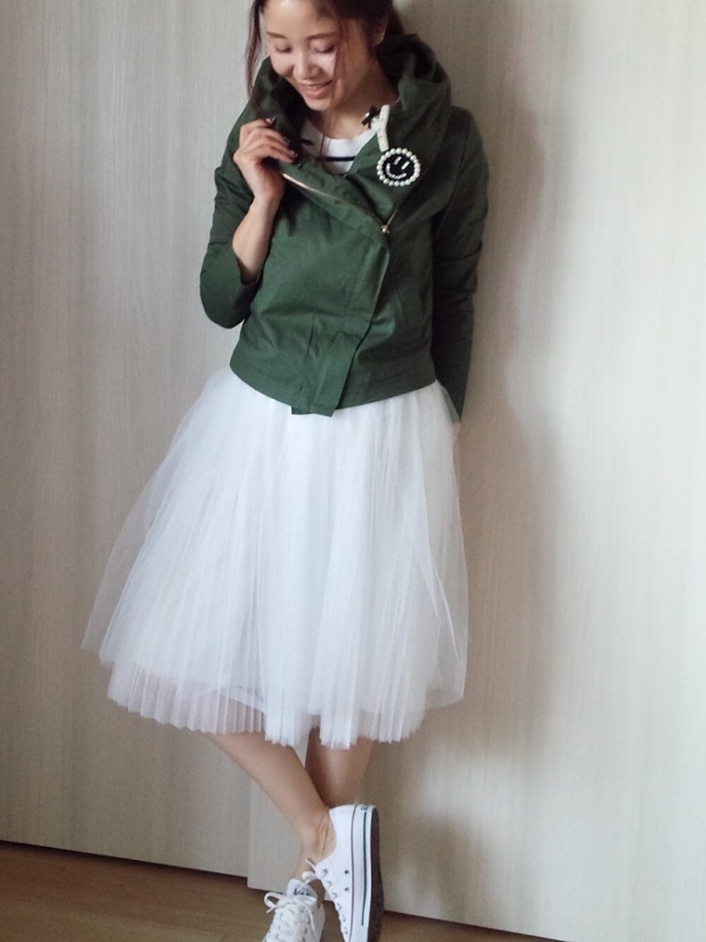 グリーン系のミリタリージャケット、ホワイト系のスカート、ホワイト系のTシャツ/カットソーを着用したレディースの春コーディネートの1枚目の写真