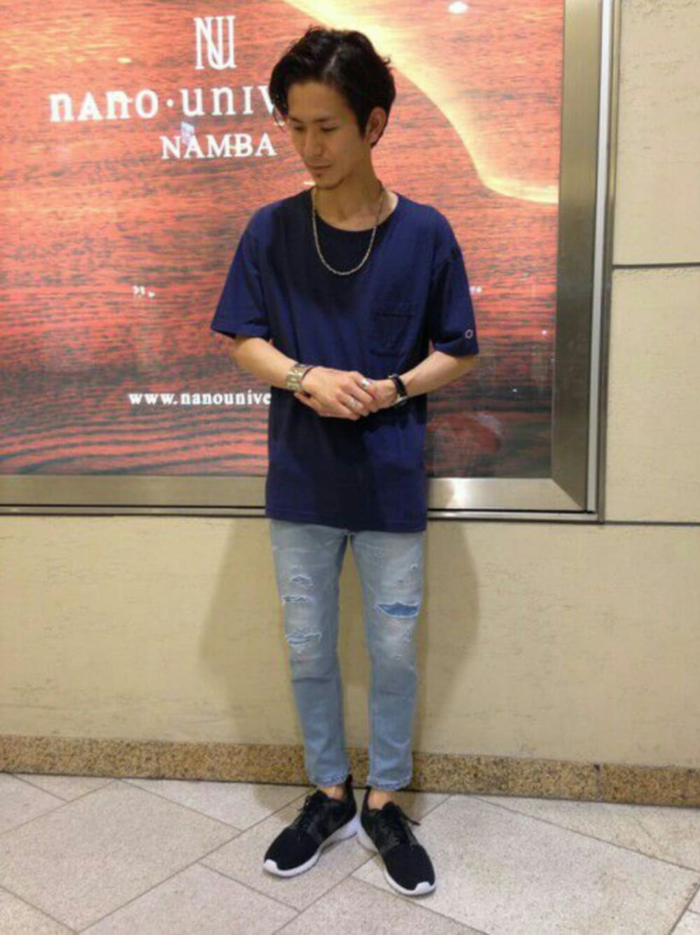 ブルー系のデニムパンツ、ブラック系のスニーカー、ブルー系のTシャツ/カットソーを着用したメンズの夏コーディネートの1枚目の写真