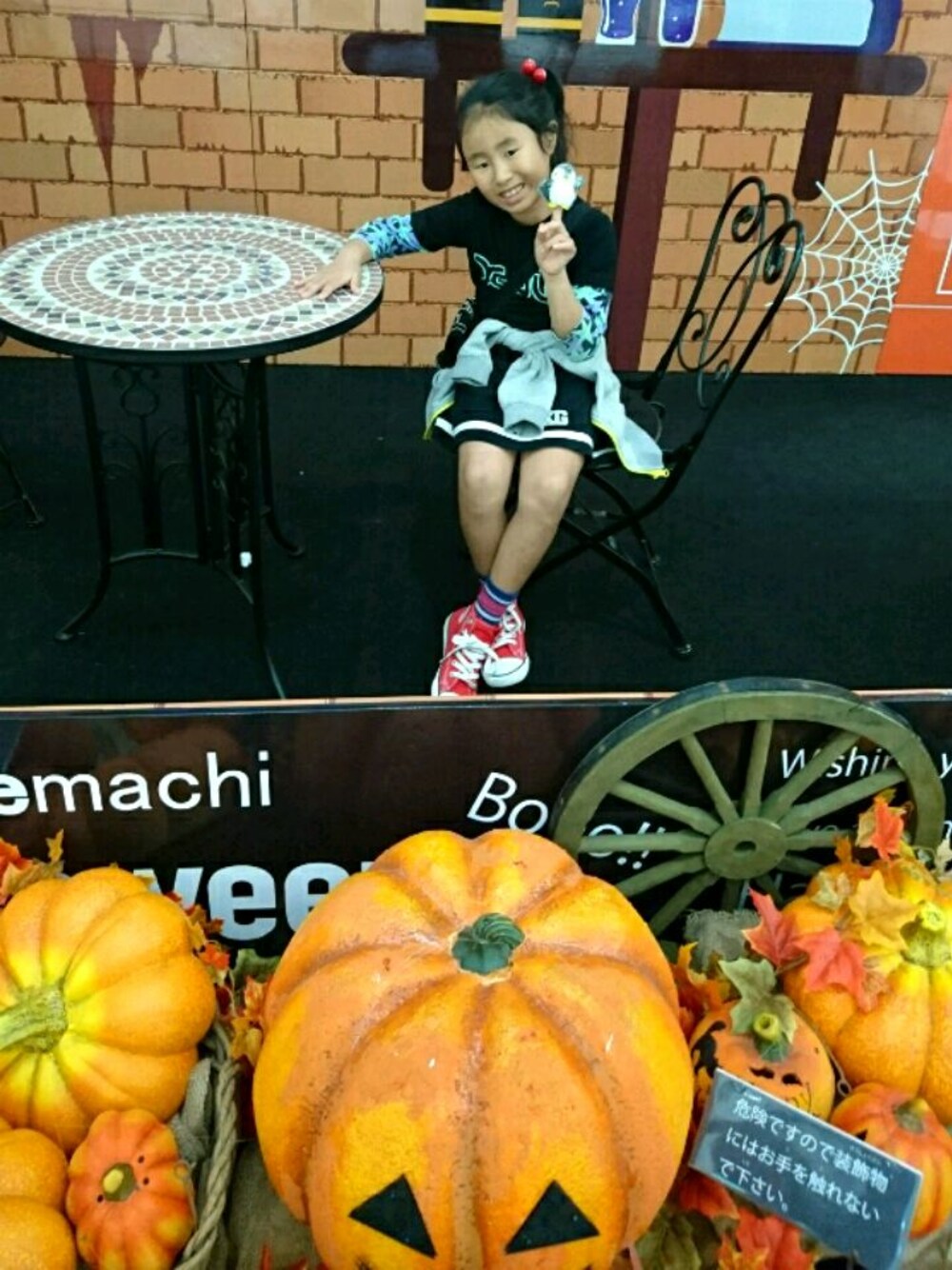 ブラック系のTシャツ/カットソー、ブラック系のスカート、レッド系のスニーカーを着用したレディースの秋コーディネートの1枚目の写真