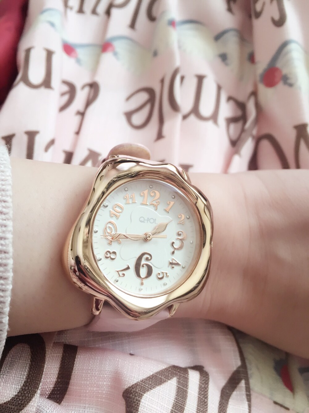 ピンク系のアナログ腕時計を着用したレディースの冬コーディネートの1枚目の写真