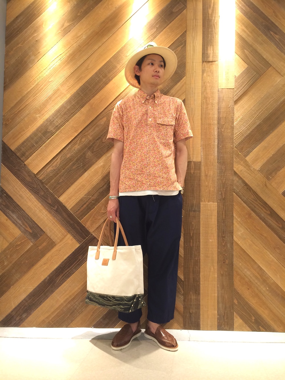 ブルー系のその他パンツ、その他のトートバッグ、ブラウン系のサンダルを着用したメンズの夏コーディネートの1枚目の写真