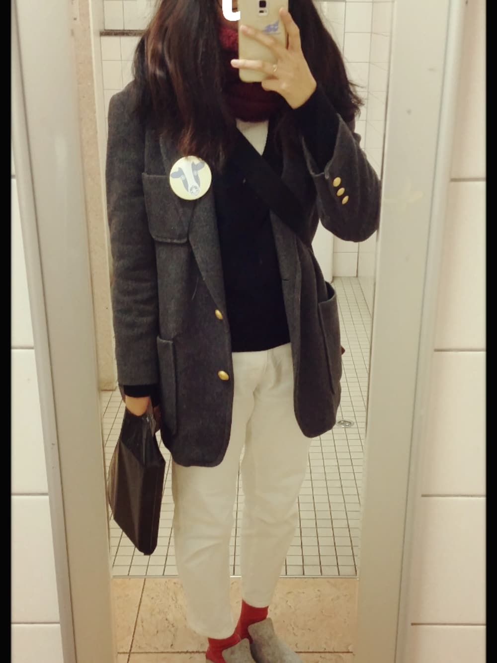 ブラック系のメッセンジャーバッグ、グレー系のサンダル、ゴールド系のピアス(片耳用)を着用したレディースの冬コーディネートの1枚目の写真