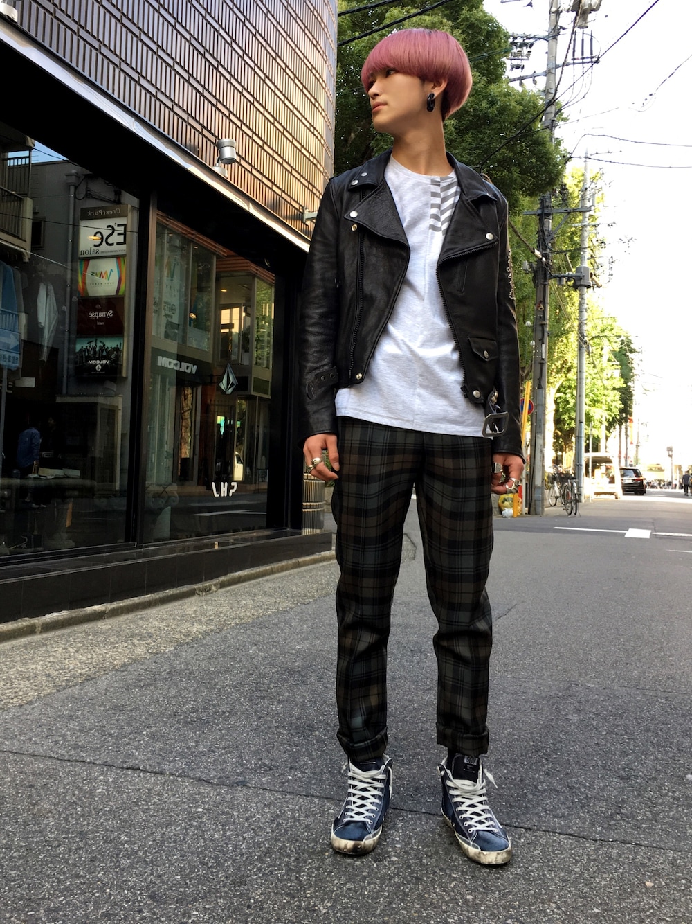 ブラック系のライダースジャケット、ブラック系のTシャツ/カットソー、グリーン系のスラックスを着用したメンズの秋コーディネートの1枚目の写真