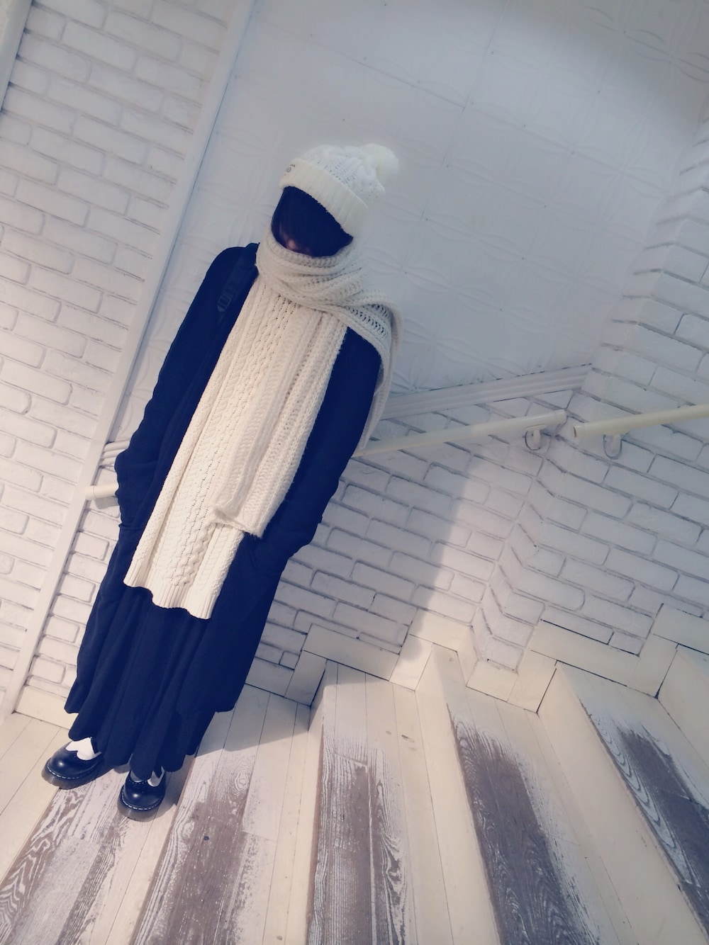 ホワイト系のニット/セーター、ブラック系のブーツを着用したメンズの冬コーディネートの1枚目の写真