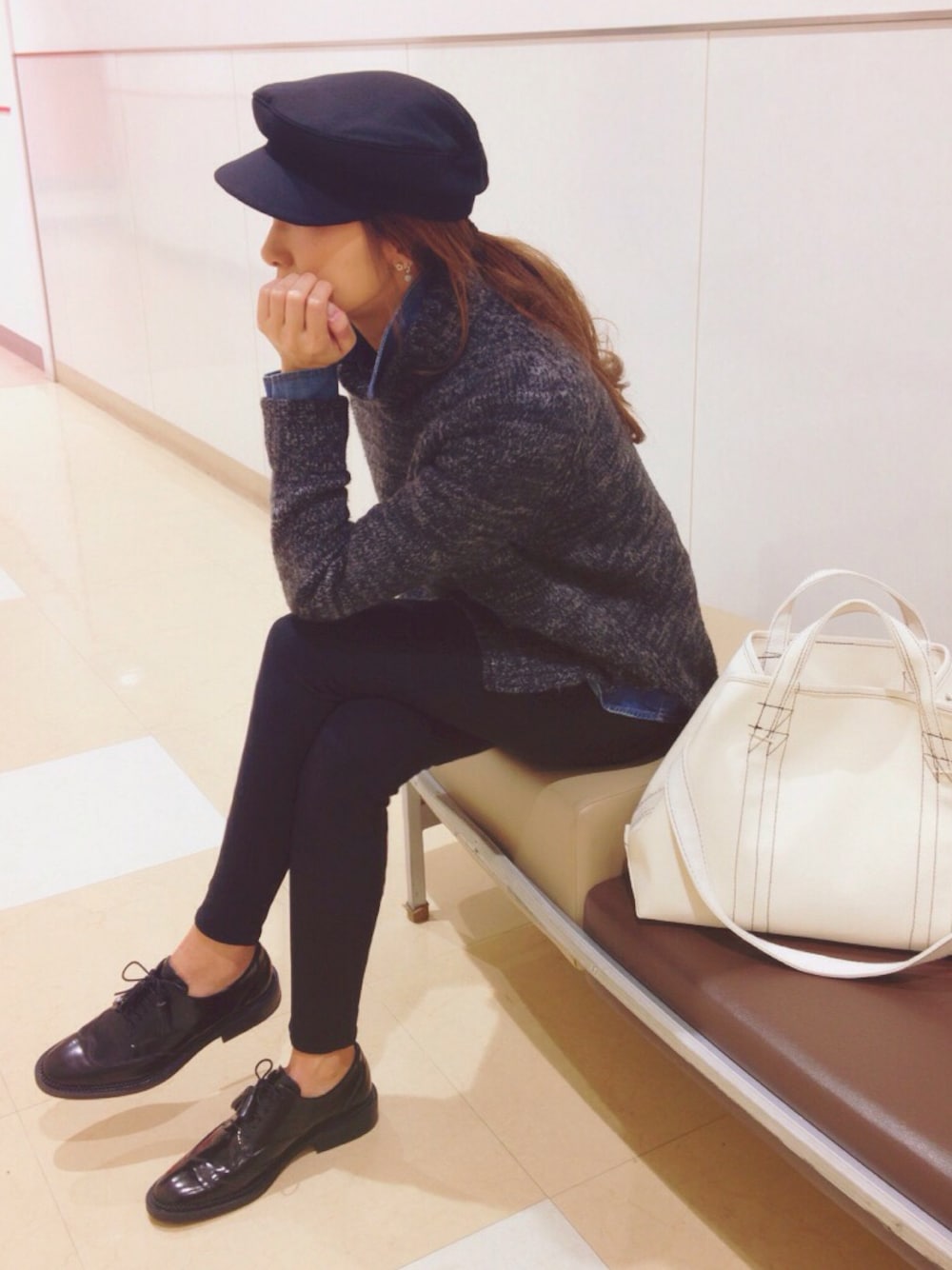 グレー系のニット/セーター、ホワイト系のショルダーバッグ、ブラック系のドレスシューズを着用したレディースの冬コーディネートの1枚目の写真