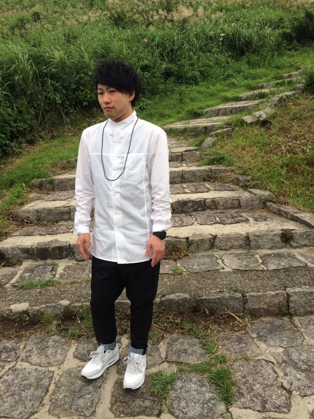 ホワイト系のシャツ/ブラウス、ブラック系のデニムパンツ、ホワイト系のスニーカーを着用したメンズの秋コーディネートの1枚目の写真