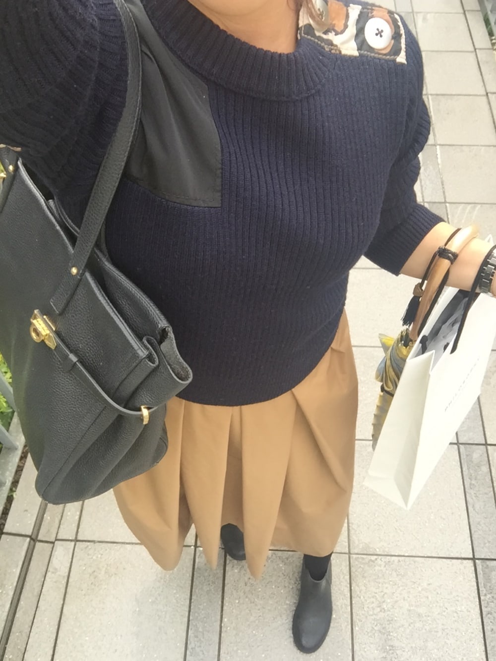 ブルー系のニット/セーター、ベージュ系のスカートを着用したレディースの秋コーディネートの1枚目の写真