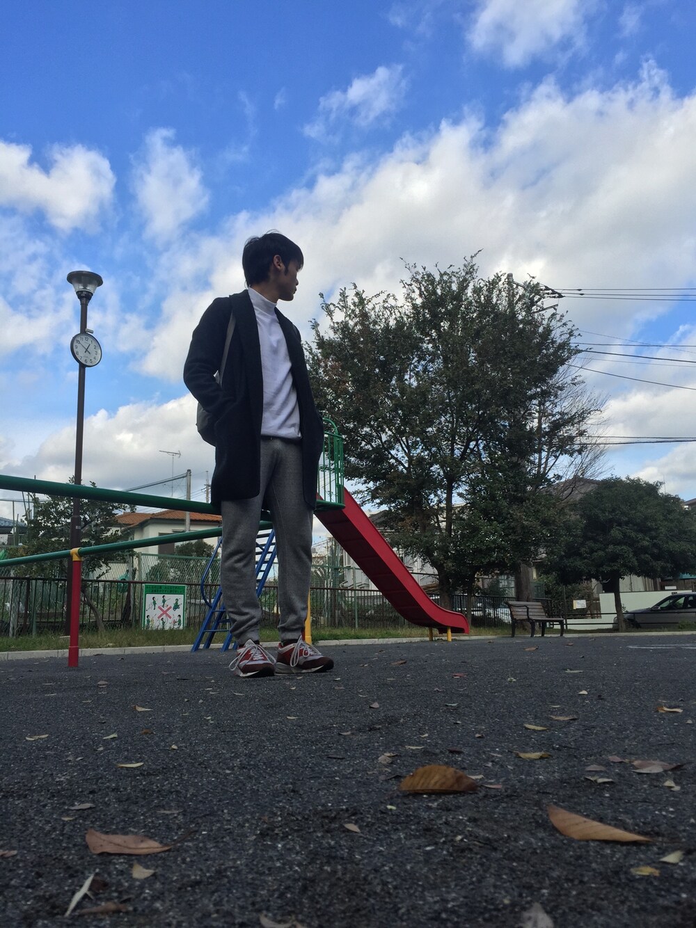 ブラック系のチェスターコート、ホワイト系のTシャツ/カットソー、グレー系のその他パンツを着用したメンズの秋コーディネートの1枚目の写真