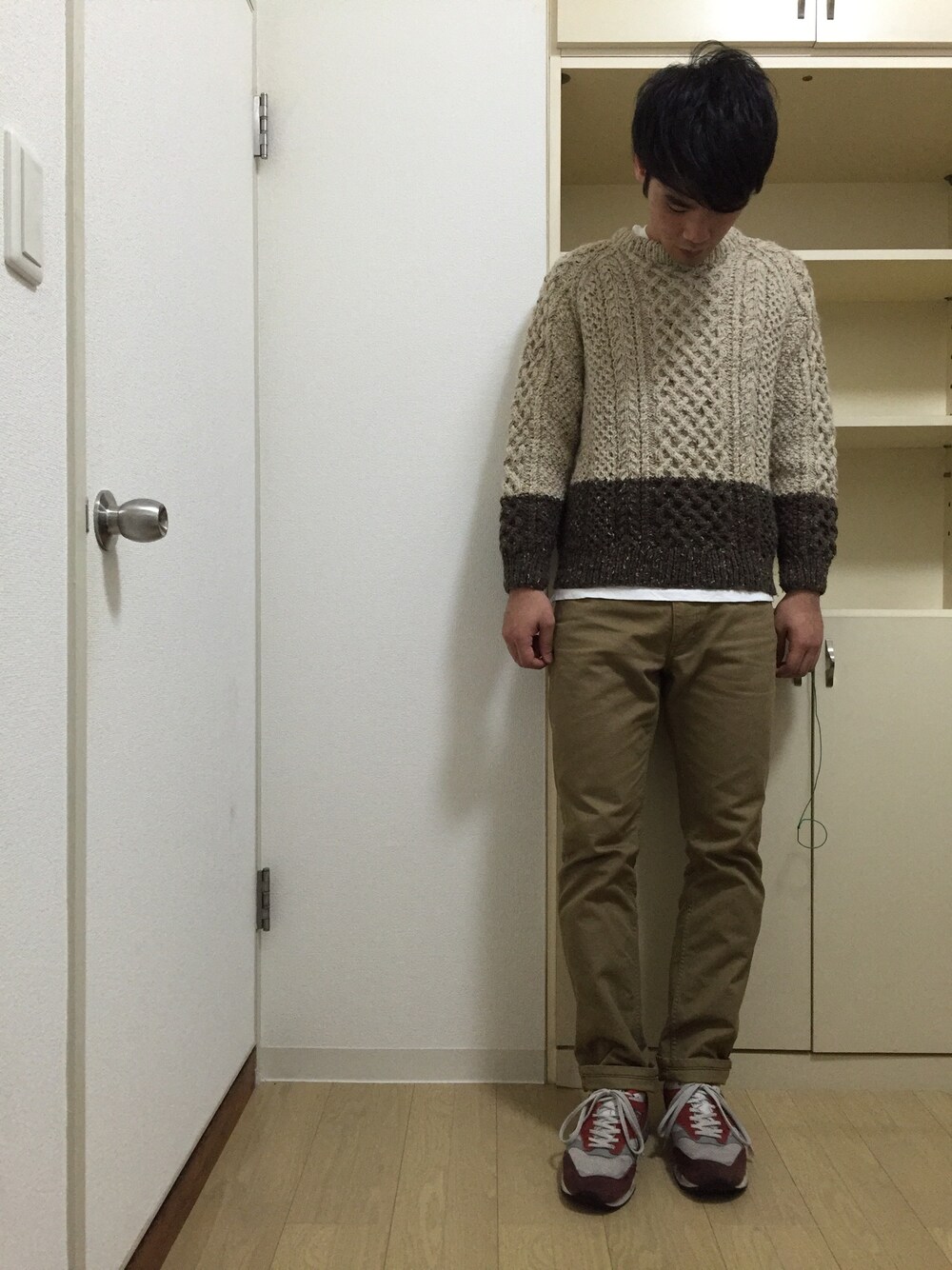 ブラウン系のニット/セーター、ブラウン系のその他パンツ、レッド系のスニーカーを着用したメンズの冬コーディネートの1枚目の写真